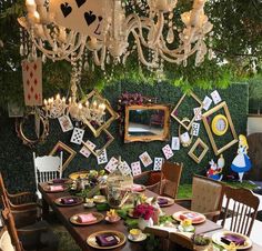 a table set up for a party with cards hanging from the ceiling