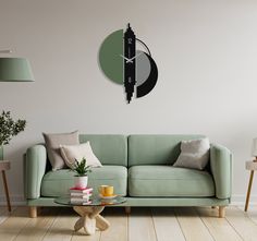 a living room with a green couch and clock on the wall