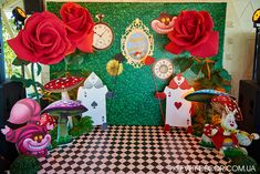 there are many decorations on the wall with red roses in front of them and some fake mushrooms