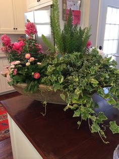 an arrangement of flowers in a bowl on a kitchen counter