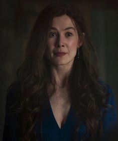 a woman with long dark hair in a blue dress