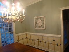 a chandelier hanging from the ceiling in a room with blue walls and white trim