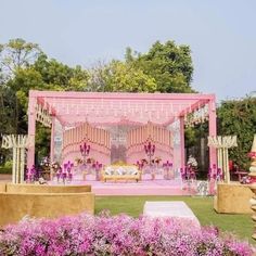 an outdoor wedding setup with pink flowers in the foreground