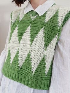 a woman wearing a green and white knitted sweater with an arrow pattern on it