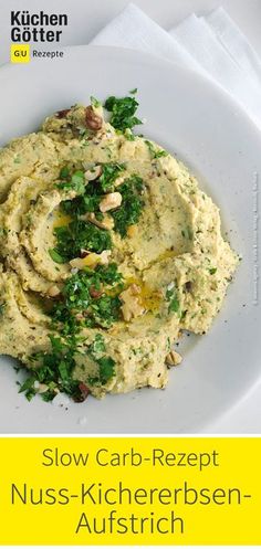 a white plate topped with hummus and greens