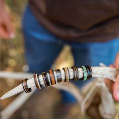 a person holding a long piece of wood with rings on it's end in their hand