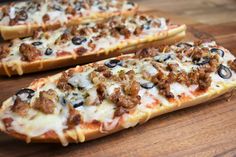 two slices of pizza sitting on top of a wooden cutting board next to each other