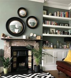 a living room filled with furniture and a fire place in front of a book shelf