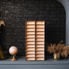 a shelf with some vases and other items on it next to a brick wall