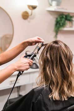 a woman is getting her hair cut at the salon