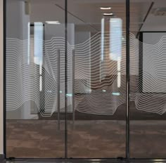 an office building with glass doors that have wavy lines drawn on the glass to make it look like waves