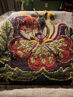 an embroidered purse sitting on top of a couch