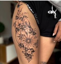 a woman's thigh with flowers and a bird on it