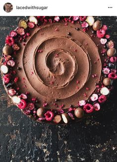 a chocolate cake with pink flowers on top