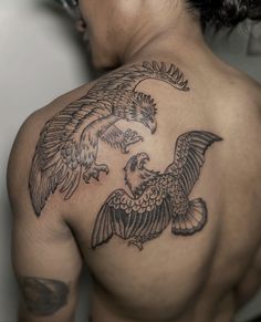 a man with a tattoo on his back has an eagle and fish design on it