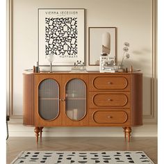 a wooden cabinet with glass doors in a living room next to a rug and pictures on the wall