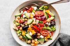 a salad with cucumbers, tomatoes, chickpeas and feta cheese