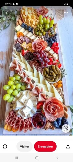 an assortment of cheeses, fruits and meats on a platter