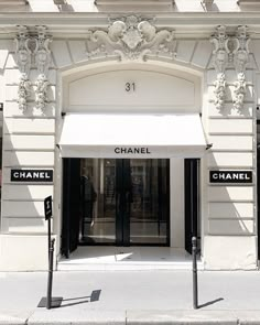 the entrance to a chanel store with white awnings and black door handles