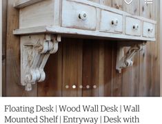 an old wooden desk with white paint on the top and bottom shelf, attached to a wood paneled wall