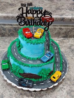 a birthday cake with cars on the road and happy birthday sign