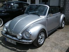 an old vw beetle parked in front of a building