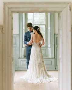 the bride and groom are looking at each other in their wedding photo taken through an open doorway