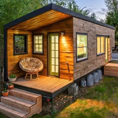 the tiny house is made out of wood and has a couch on the front porch