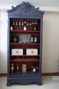 an old china cabinet with wine glasses and liquor bottles