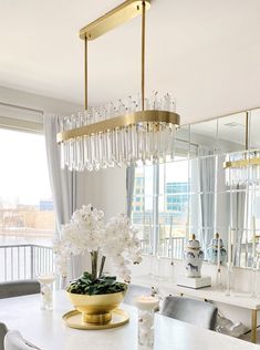 a dining room table with chairs and a chandelier hanging from the ceiling over it