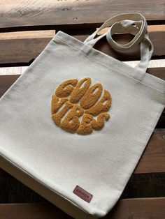 an embroidered bag sitting on top of a wooden bench