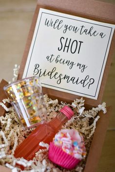 a cupcake and some drinks in a box with a sign that says, will you take a shot at being my bridesmaid?