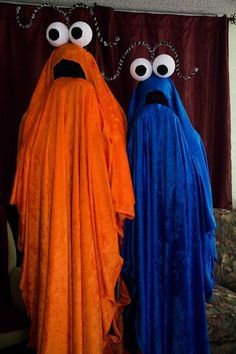 two people dressed in costumes standing next to each other with googly eyes on their faces