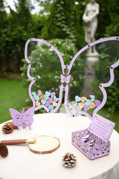 a white table topped with a cake covered in frosting next to a purple butterfly