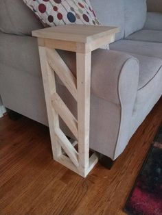 a small wooden table sitting on top of a hard wood floor next to a couch