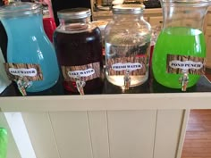 there are many different types of liquid in the jars on the counter top, including blue and green