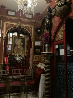 an ornately decorated room with red walls and chandelier hanging from the ceiling