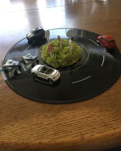 a toy car is on top of a black plate with cars and trees in it