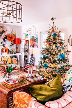 a living room with a christmas tree in the corner and other decorations on the wall