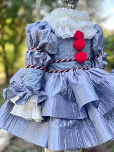 a blue dress with red pom poms on it