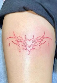 a woman's thigh with tattoos on her legs and the word love written in red ink