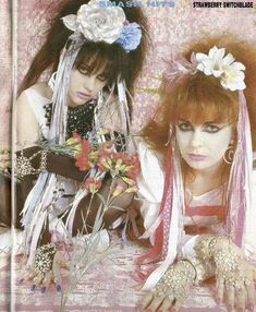 two women with long hair and flowers on their heads are posing for a magazine cover