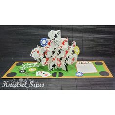 an origami card game with cards and dices on the mat in front of it