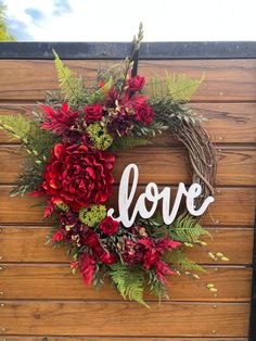 a red and green wreath with the word love spelled in white letters on top of it