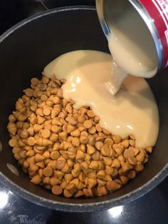 milk being poured into a bowl filled with chickpeas and other foodstuffs