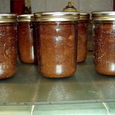 four jars filled with brown sugar sitting on top of a counter