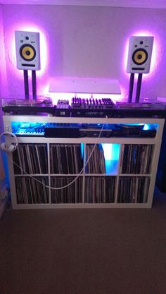 an entertainment center with speakers, tape recorders and other electronic equipment in front of a purple light