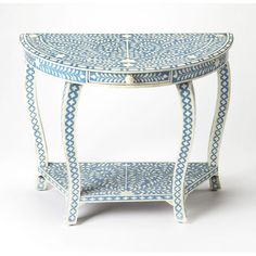 a blue and white table with an intricate design on the top, sitting against a white background