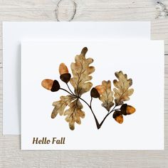 a card with watercolor leaves and the words hello fall on it's front