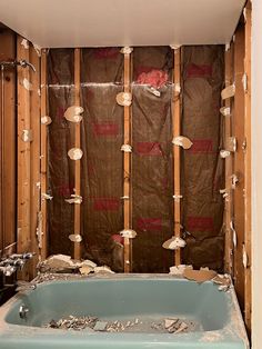 a bath tub sitting inside of a bathroom under construction on the side of a wall